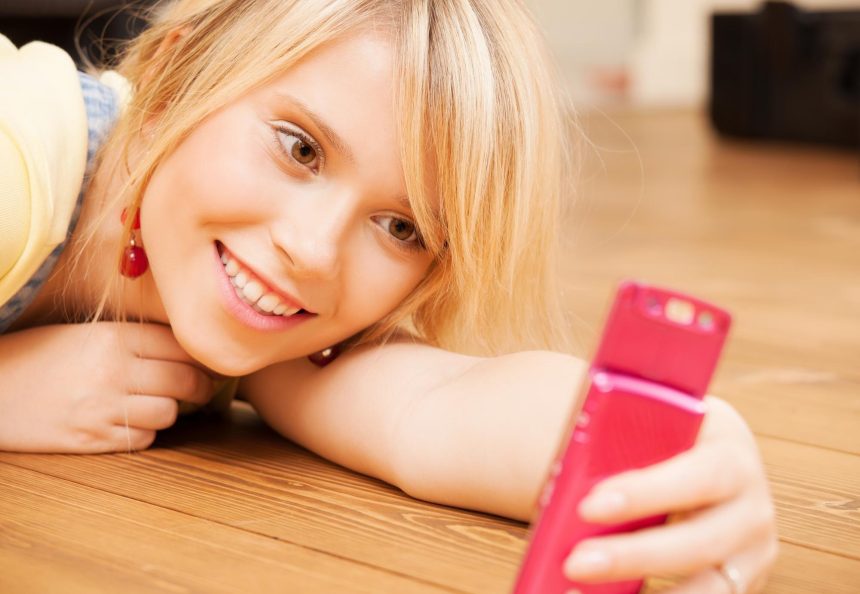 koncepcja technologii - nastolatka robi autoportret za pomocą smartfona