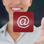 Kompozycja uśmiechniętej bizneswoman dotykającej ekranu z ikoną cyfrowej wiadomości e-mail
