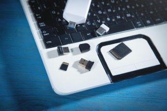 Pendrive i karty pamięci na klawiaturze komputera.
