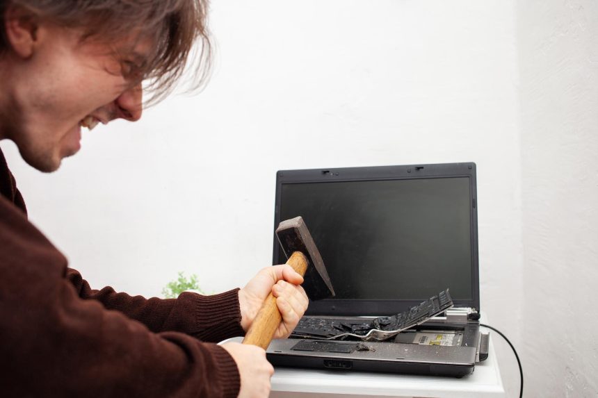 Mężczyzna pracujący w biurze rozbił laptop zniszczył komputer gniew nienawiść podrażnienie błąd uszkodzenie hamulców nie chce pracować złe emocje depresja nie zachowane krzyki