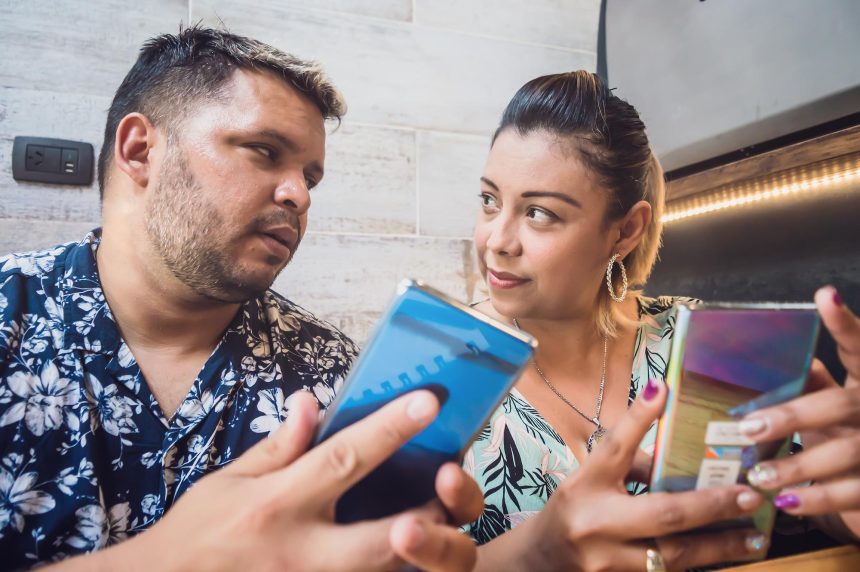 para siedząca w restauracji pokazuje jej telefon podczas rozmowy
