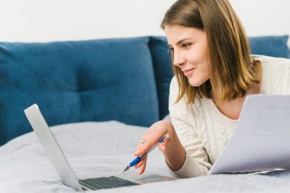 Kobieta wyszukuje laptop z papierami