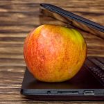 Laptop z jabłkiem na drewnianym tle