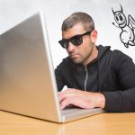 Przestępca na laptopie z ikoną diabła unoszącą się obok