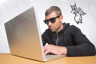 Przestępca na laptopie z ikoną diabła unoszącą się obok