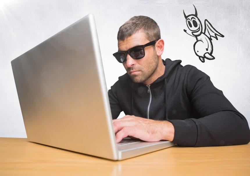Przestępca na laptopie z ikoną diabła unoszącą się obok