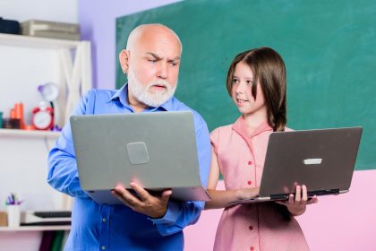 Pomóż uczyć się nowej technologii w nauce szkolnej lekcji online Wyszukiwarka mała dziewczynka z mężczyzną nauczyciel nauka na komputerze edukacja blogowanie Powrót do szkoły dojrzały nauczyciel pomóż uczniowi dziewczyna