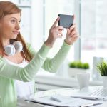 Portret młodej bizneswoman biorącej selfie w biurze