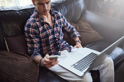 Człowiek internet i freelancer lub telefon na kanapie online badania i pisanie dla mediów społecznościowych Człowiek zdalna praca i plan propozycji na stronie internetowej laptop i dom dla sieci dla kontaktu biznesowego