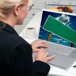 Kobieta w kuchni używająca laptopa z pustym znakiem drogowym na ekranie