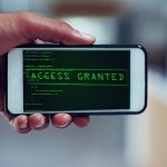 Nawet Twój smartfon nie jest bezpieczny Ujęcie niezidentyfikowanego mężczyzny, który używa smartfona do włamania się do sieci komputerowej