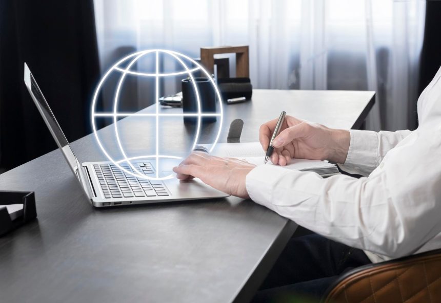 Biznesmen pracujący na laptopie wyszukujący informacje w Internecie robiący notatki w planerze analizującym rynek globalny lub komunikujący się z międzynarodowymi partnerami