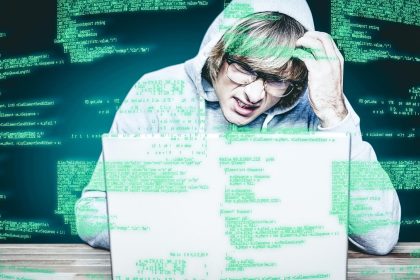 Złożony obraz mężczyzny w kurtce z kapturem włamującego się do laptopa