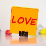 Różowy list z napisem LOVE na drewnianym tle