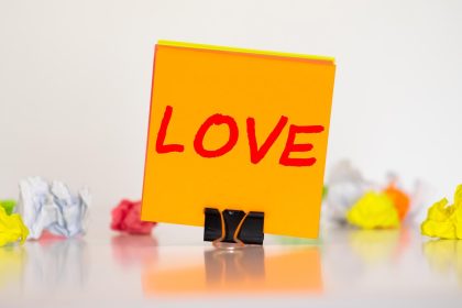 Różowy list z napisem LOVE na drewnianym tle