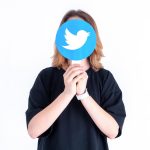 Kaukaski nastolatek trzymający w dłoniach zdjęcie z logo Twittera na białym tle