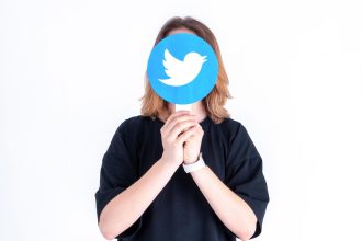 Kaukaski nastolatek trzymający w dłoniach zdjęcie z logo Twittera na białym tle
