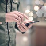Chmura danych sieciowych Mężczyzna trzyma telefon w dłoni i naciska ekran
