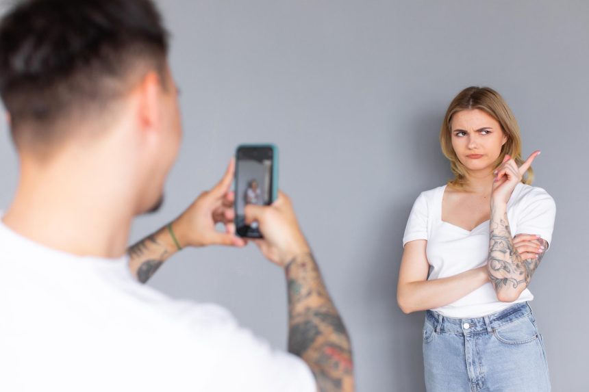 Uśmiechnięta para używająca telefonów w studio Izolowane ciemne tło