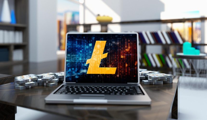 Złota moneta litecoin w laptopie na tle pokoju biurowego