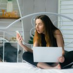 atrakcyjna kobieta korzystająca z laptopa i uśmiechająca się o poranku