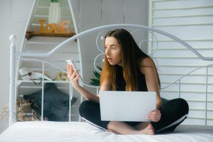 atrakcyjna kobieta korzystająca z laptopa i uśmiechająca się o poranku