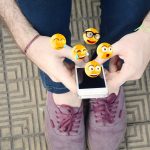 Mężczyzna używa smartphone wysyłania emoji.