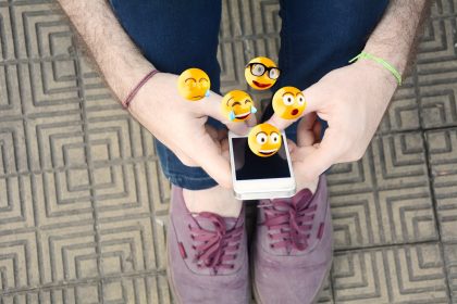 Mężczyzna używa smartphone wysyłania emoji.