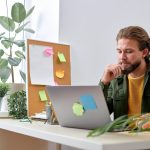 Miły kaukaski mężczyzna przedsiębiorca pracujący na laptopie w nowoczesnym biurze przystojny amerykański lub kaukaski facet