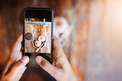 Ręce osoby i smartfona do fotografowania kawy na stole w kawiarni dla projektu artystycznego lub w mediach społecznościowych Influencer jedzenie i ekran z kubkiem w restauracji na obiad lub przerwę z aplikacją mobilną