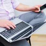 Biznesmen w garniturze za pomocą laptopa w tle