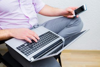 Biznesmen w garniturze za pomocą laptopa w tle