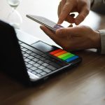 Ręce używające laptopa i telefonu do zakupów online zbliżą czysty obraz przed oknem w miękkim świetle