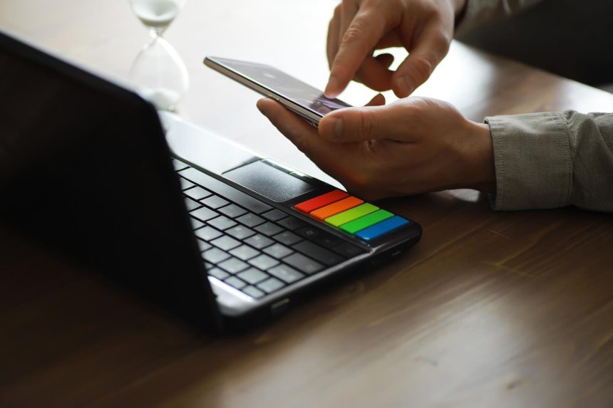 Ręce używające laptopa i telefonu do zakupów online zbliżą czysty obraz przed oknem w miękkim świetle