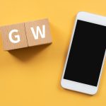 Drewniane klocki z tekstem koncepcji GW i smartfonem.