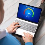 Mężczyzna sprawdzający prędkość połączenia internetowego na laptopie