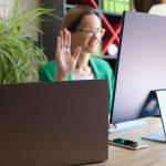 Zbliżenie wesołego menedżera biorącego udział w spotkaniu online w biurowej kobiecie patrzącej na ekran i