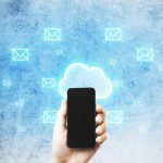 Ręka za pomocą smartfona i świecącego hologramu mapy e-mail w chmurze