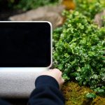 osoba trzymająca laptop, który ma ekran, który mówi dotyk na nim