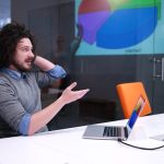 Grupa młodych biznesmenów omawiająca plan biznesowy w nowoczesnym budynku biurowym dla startupów