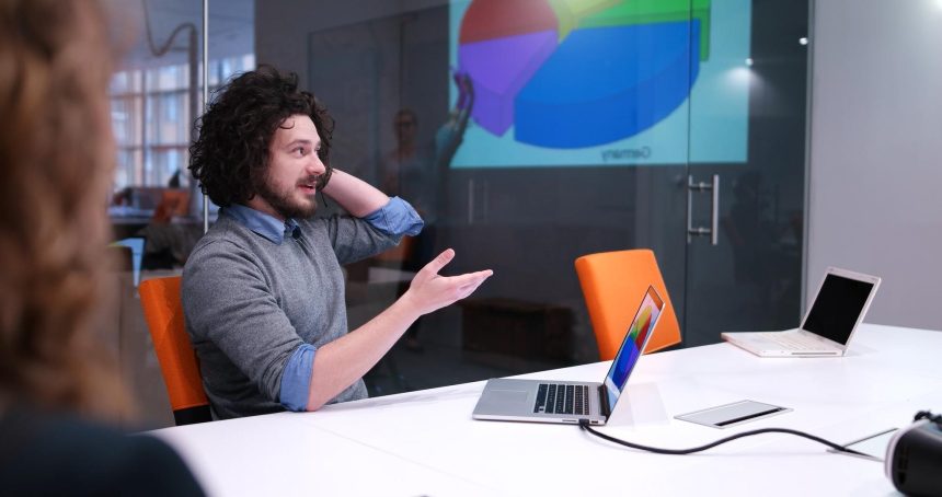Grupa młodych biznesmenów omawiająca plan biznesowy w nowoczesnym budynku biurowym dla startupów