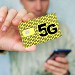 Mężczyzna trzyma żółtą kartę sim z napisem g i telefon komórkowy w ręku zastępując kartę sim