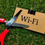 Koncepcja technologii Tekst WIFI pisze na brązowej karcie z nożyczkami na tle trawy