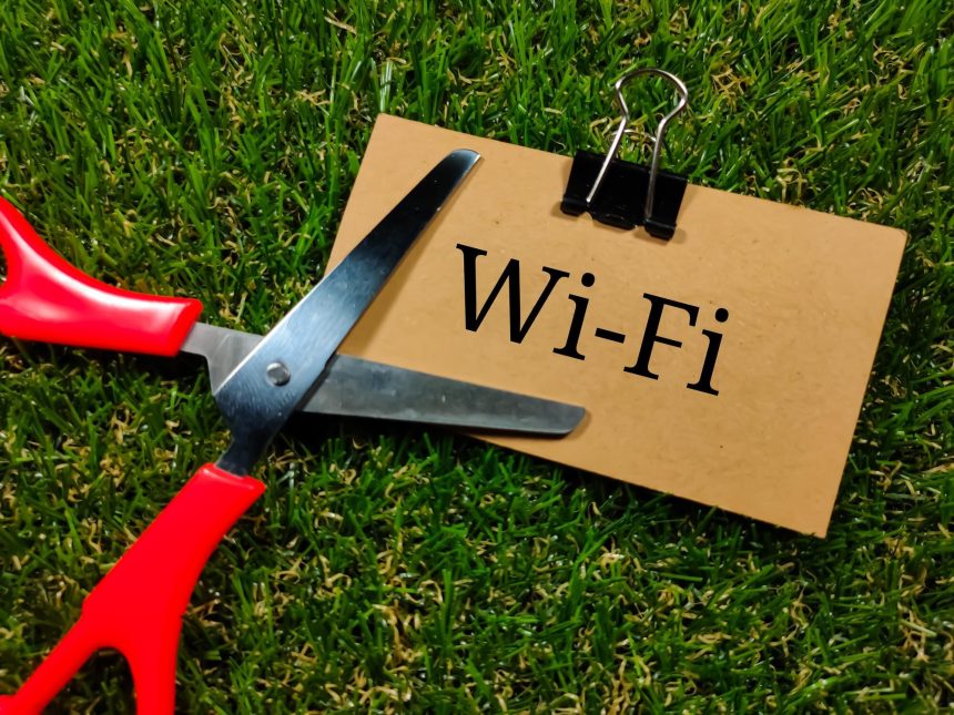 Koncepcja technologii Tekst WIFI pisze na brązowej karcie z nożyczkami na tle trawy