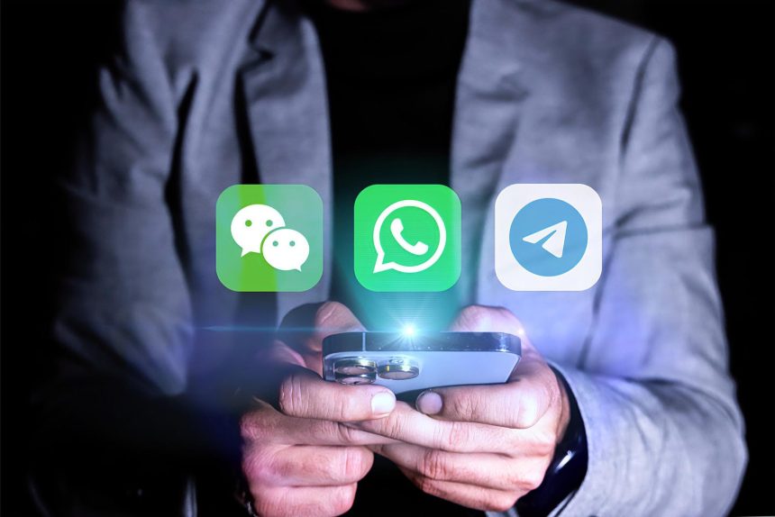 Mężczyzna trzyma komórkę z zieloną ikoną z napisem "Messenger"