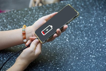Zbliżenie rąk kobiety ładującej telefon komórkowy z ikoną ładowania