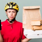 Ładna blondynka doręczycielka z papierową torbą