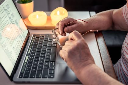 Stara kobieta czyta wiadomość na ręce zbliżenia laptopa