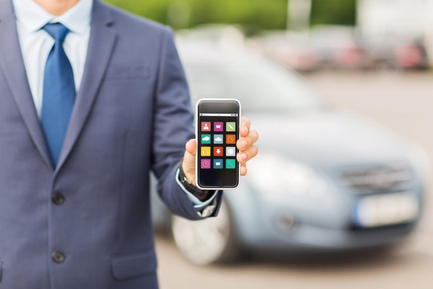 transport, podróż służbowa, koncepcja multimediów, technologii i ludzi - zbliżenie człowieka pokazującego ikony menu ekran smartfona na parkingu