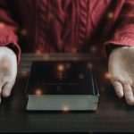Zbliżenie otwartej Biblii z krzyżem na poranne nabożeństwo na drewnianym stole